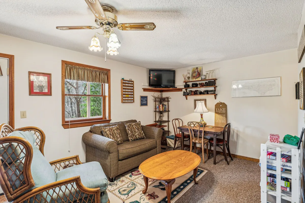 A spacious, open living area with a comfortable sofa, dining table, lamp, wall art, and a TV. The arrangement encourages relaxation, socializing, or watching movies together—ideal for flexible sleeping arrangements with the pull-out sofa.